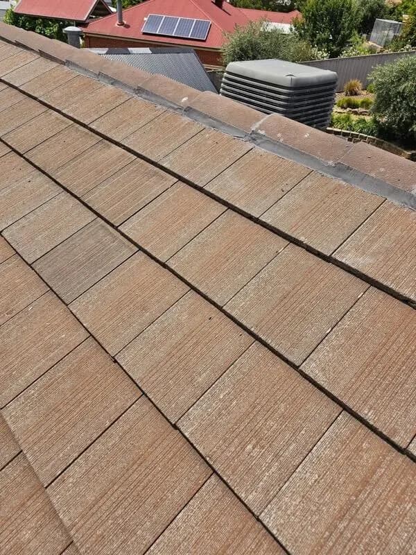 Storm damage to a tile roof with a hole through to the timber battens